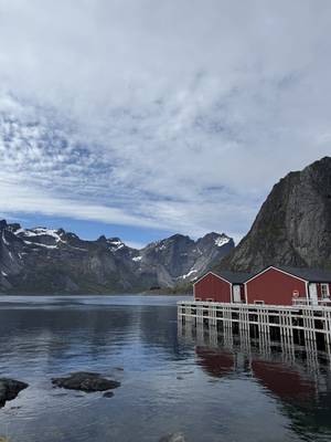 Lofoten Rundreise - rote Fischerhütten in Hamnøy vor dramatischen Berggipfeln